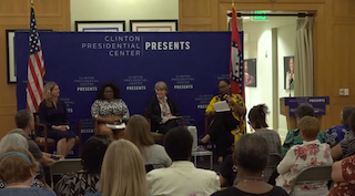 Four women sit on a dais in front of a background with text "Clinton Presidential Center Presents"