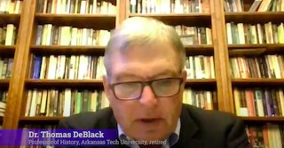 Dr. Thomas DeBlack wears glasses and sits in front of a tall bookcase with subtitle "Dr. Thomas DeBlack, Professor of History, Arkansas Tech University, retired"