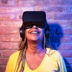 Senior African woman having fun playing with innovated virtual reality glasses - Tech gaming entertainment concept
