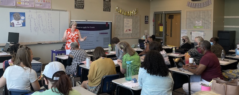 Ann Clemments addresses adults sitting at desks in a classroom